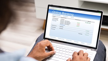 Online banking su pc e mani che scrivono